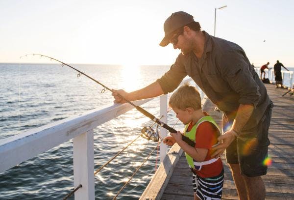 Dad teaching son to fish